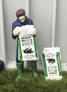 WM078J - Granjero vaciando una bolsa de alimento para caballos
