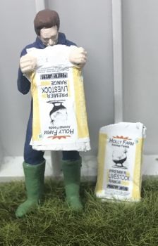 WM078K - Granjero vaciando una bolsa de alimento para aves